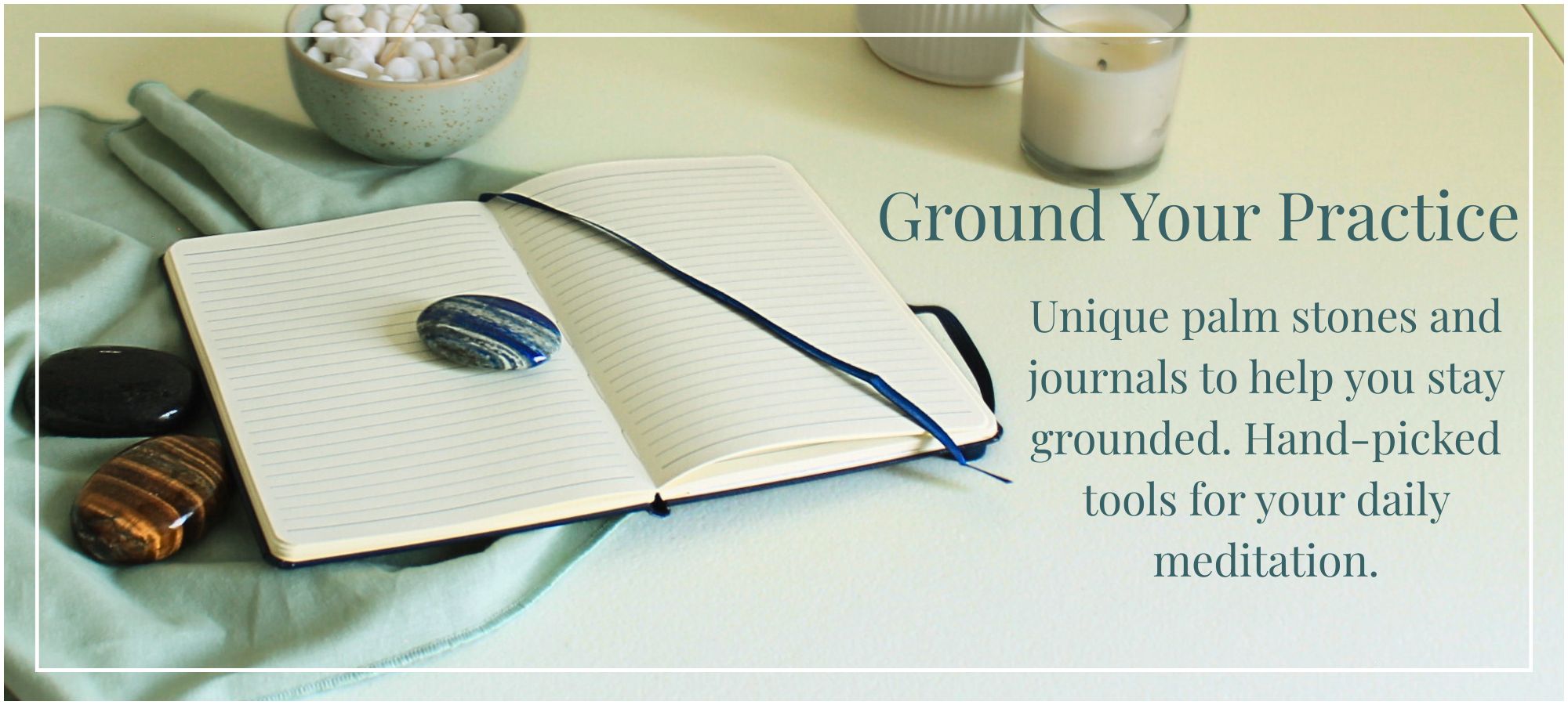 Close-up of unique hand-carved palm stones and an open lined journal for grounding practices, positioned as essential tools for daily mindfulness and reflection. Text reads: "Ground Your Practice. Unique palm stones and journals to help you stay grounded. Hand-picked tools for your daily meditation."